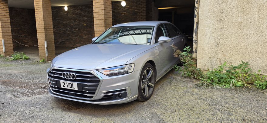 A silver car parked in a car park, undamaged